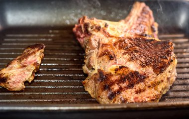 Büyük parça üzerinde ızgara tava hazırlanan taze sığır eti biftek.