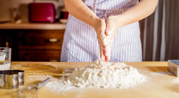 Le mani di donna impastano la pasta su un tavolo — Foto Stock