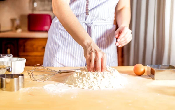 Facendo la pasta da mani femminili su tavolo di legno — Foto Stock