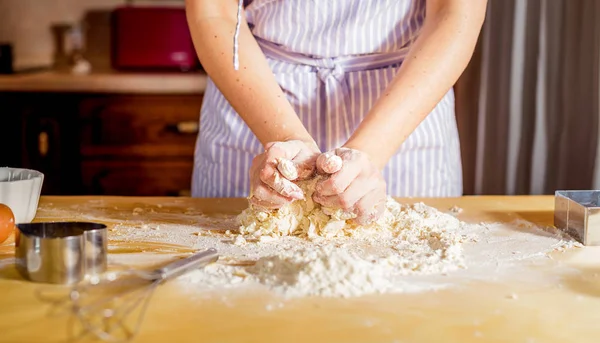 Facendo la pasta da mani femminili su tavolo di legno — Foto Stock