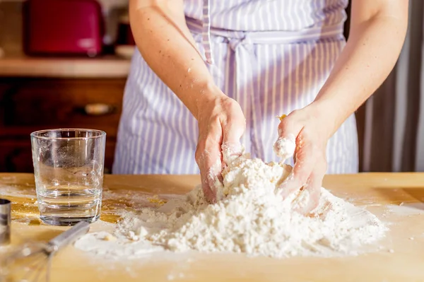 Faire la pâte par les mains féminines sur la table en bois — Photo