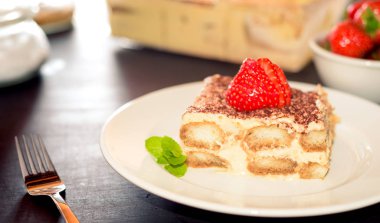 tiramisu keki çilek İtalyan mutfağı ile dekore edilmiştir.