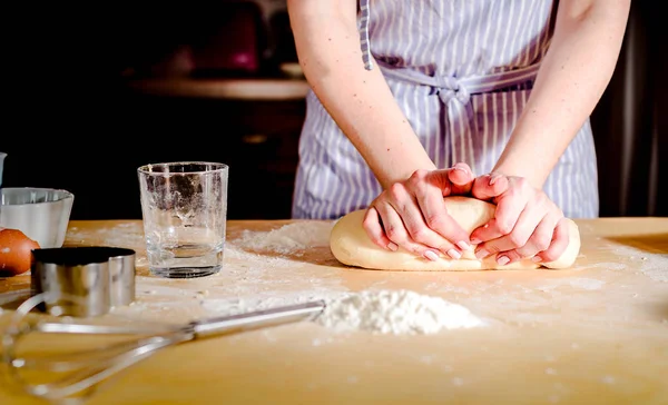 Mani femminili che fanno la pasta sul tavolo di legno — Foto Stock