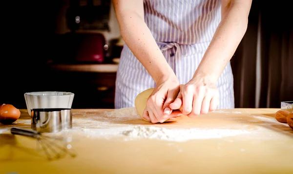 Kobiecych rąk wyrabiania ciasta na drewnianym stole — Zdjęcie stockowe