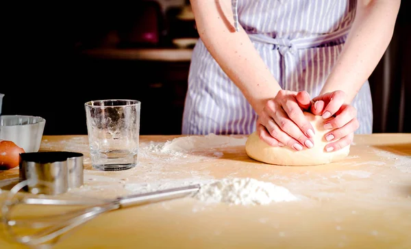 Mani femminili che fanno la pasta sul tavolo di legno — Foto Stock