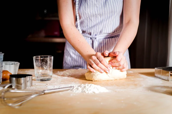 Female hands making dough on wooden table — Stock Photo, Image