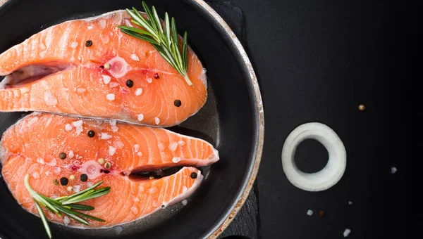 生鲑鱼牛排在深色石头背景与洋葱，迷迭香，香料，概念饮食，不饱和脂肪，欧米茄3 — 图库照片