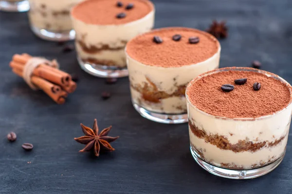 Tiramisu in a glass decorated with coffee beans on a dark background — Stock Photo, Image