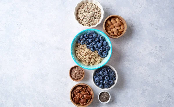 Ingredientes para um café da manhã saudável, quinoa com mirtilo, figo, mel e nozes. Conceito vegan e alimentação saudável. Vista superior — Fotografia de Stock