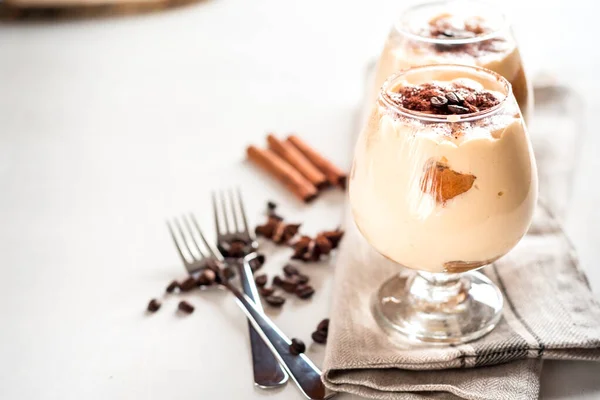 Tiramisu de sobremesa italiano requintado em copos de conhaque em um branco — Fotografia de Stock