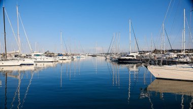 Gün batımında rıhtımdaki yatlar suda yansıyor. Akdeniz.