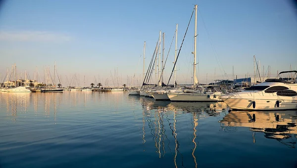 Яхти на причалі під час заходу сонця з віддзеркаленням у воді. Середземне море. — стокове фото