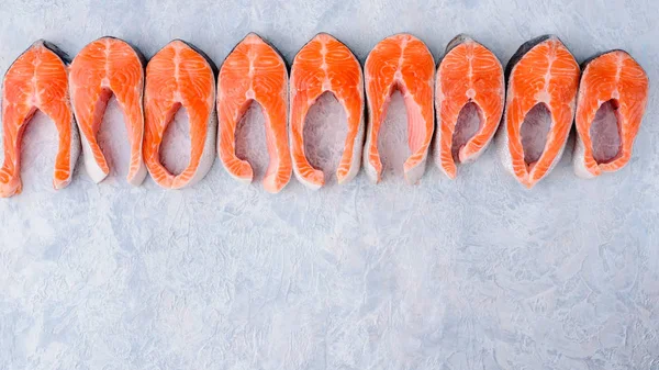 Patrón de filetes de salmón crudo en una vista superior de fondo azul — Foto de Stock