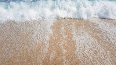 abstract background of sea waves, on golden sand, white sea foam, sunlight