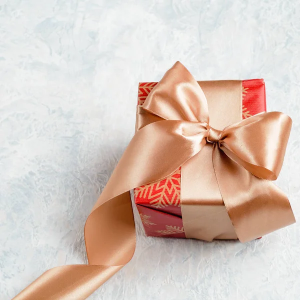 Red christmas gift with golden bow on a white background — Stock Photo, Image