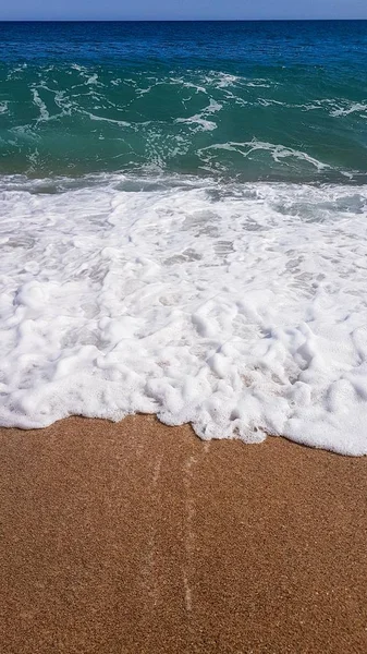 Abstrakter Hintergrund von Meereswellen, auf goldenem Sand, weißem Meeresschaum, Sonnenlicht — Stockfoto