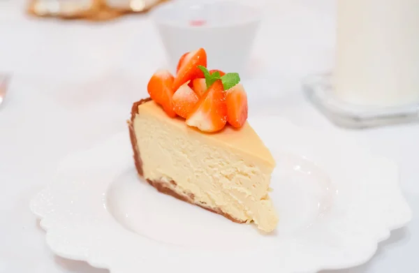 Tarta de queso fresa fresca en un plato de cerámica en una mesa festiva blanca — Foto de Stock