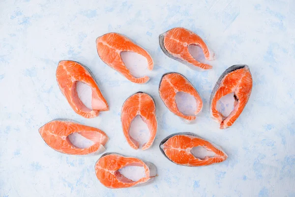 Padrão de bifes de salmão cru em um fundo azul vista superior — Fotografia de Stock