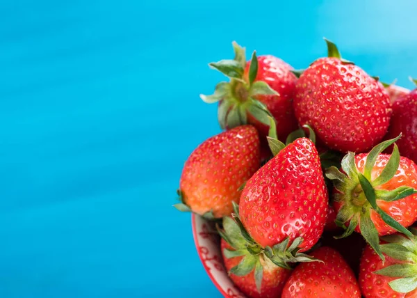 Erdbeeren in einer bunten Schüssel auf buntem Hintergrund — Stockfoto
