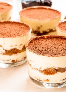 karanlık bir arka plan üzerinde kahve çekirdekleri ile dekore edilmiş bir cam tiramisu