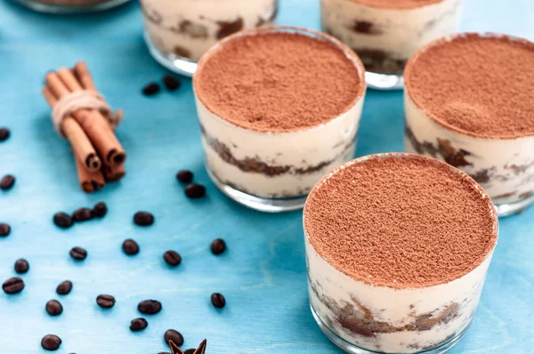 Tiramisu em um copo decorado com grãos de café em um fundo escuro — Fotografia de Stock