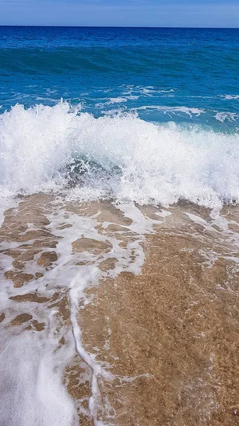 Abstrakter Hintergrund von Meereswellen, auf goldenem Sand, weißem Meeresschaum, Sonnenlicht — Stockfoto