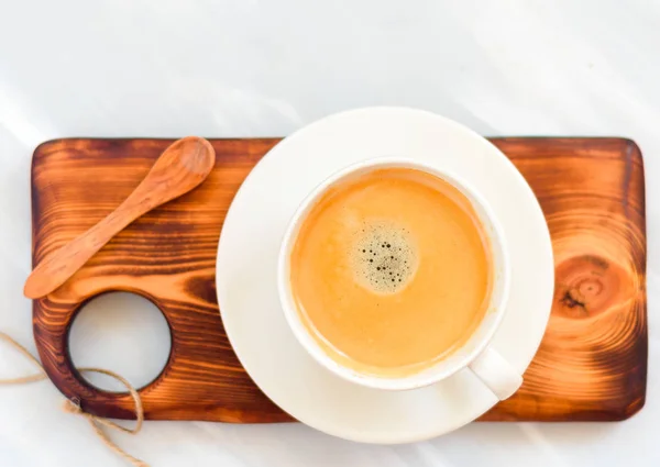 Taza de café con una cuchara de madera vista superior sobre fondo de mesa de madera — Foto de Stock