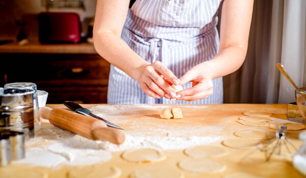 The concept of making bread, baking. Woman kneads the dough.