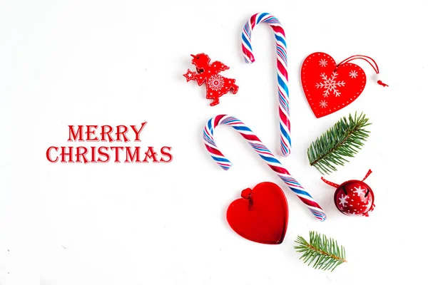 Composição de Natal com mensagem Feliz Natal, com ramos de abeto e ornamento de férias em fundo branco. Deitado plano, vista superior . — Fotografia de Stock