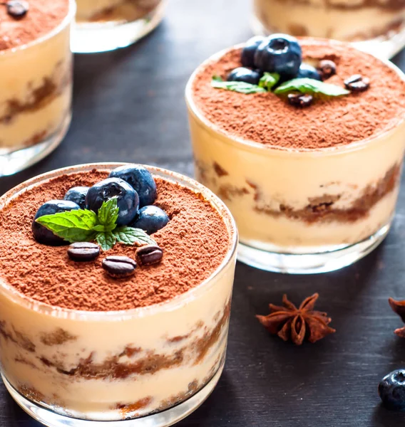 Десерт тірамісу в окулярах, прикрашений чорницею і м'ятою з кавовими зернами, концепція смачного життя — стокове фото