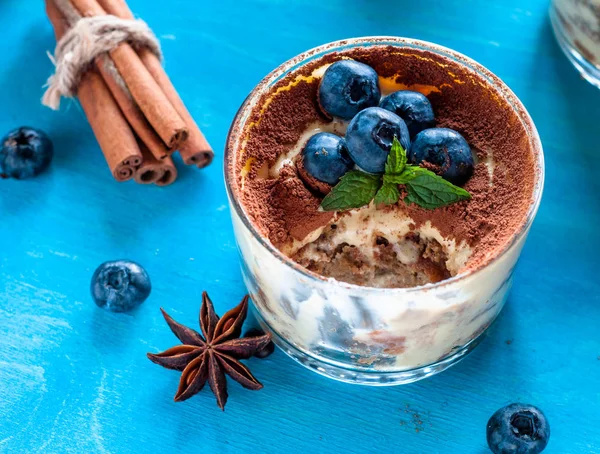 Tiramisù dolce in bicchieri, decorato con mirtilli e menta con chicchi di caffè . — Foto Stock