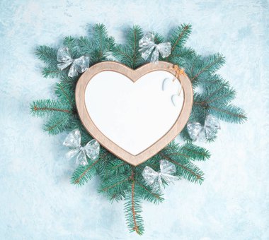 Bir kalp şeklinde Noel çerçevesi bir yeni yıl ağacı Noel süslemeleri dalları ile çevrilidir, kopya alanı ile beyaz arka planda Izole. Üst görünüm, düz yatıyordu