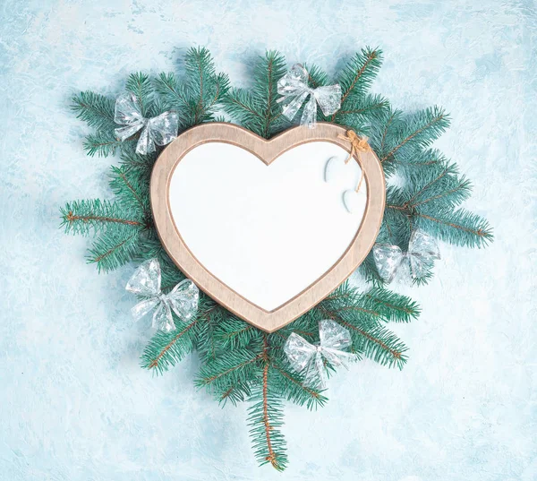 Bir kalp şeklinde Noel çerçevesi bir yeni yıl ağacı Noel süslemeleri dalları ile çevrilidir, kopya alanı ile beyaz arka planda Izole. Üst görünüm, düz yatıyordu