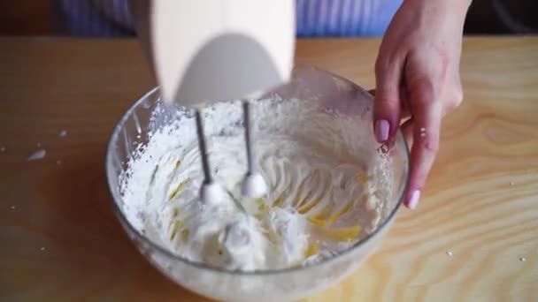 Девушка взбивает сливки для торта тирамису, замедленная съемка — стоковое видео