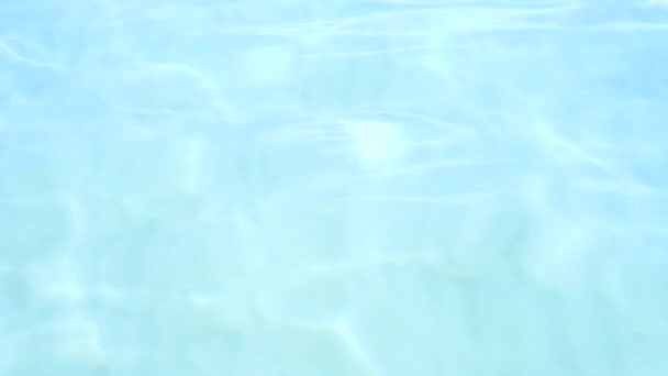 "Blue clear ocean water". Du sable blanc au fond. Réflexions solaires