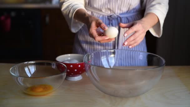 Het meisje breekt de eieren in een kom, scheidt de eekhoorns van de dooiers van het ei. Langzame beweging — Stockvideo