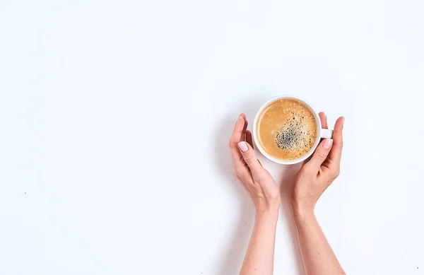 Дівчина рука тримає чашку кави на білому тлі, плоска лежала, вид зверху — стокове фото