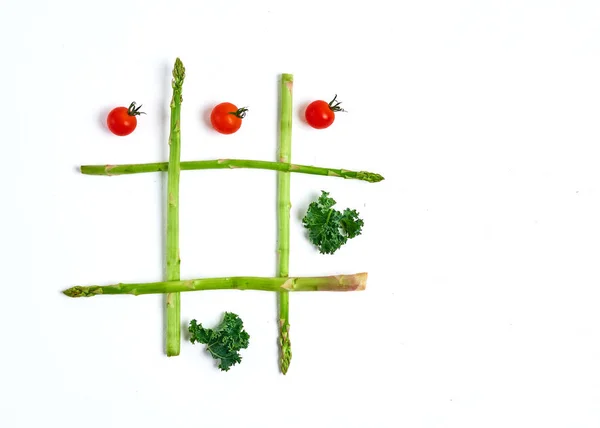 Tic tac toe con cibo, asparagi cavolo, pomodoro, vista dall'alto — Foto Stock