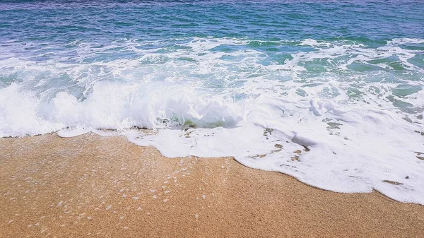 Fondo abstracto de las olas del mar, sobre arena dorada, espuma blanca del mar, luz del sol —  Fotos de Stock