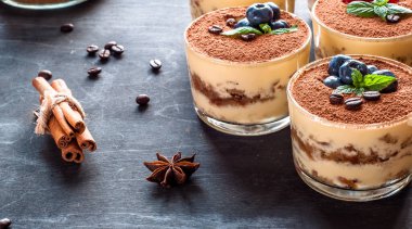 yaban mersini ve nane kahve çekirdekleri ile süslenmiş bardaklarda tatlı tiramisu.