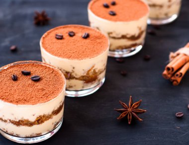 Kakaolu bardakta klasik tiramisu tatlısı ve kahve çekirdekleri, lüks tatlı.