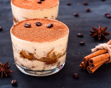Kakaolu bardakta klasik tiramisu tatlısı ve kahve çekirdekleri, lüks tatlı.