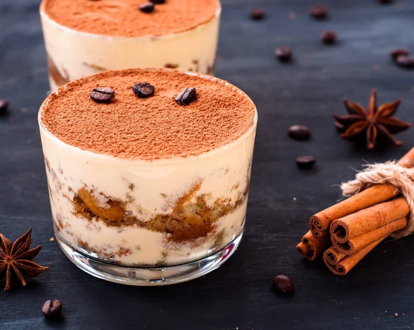 Classico dessert tiramisù in un bicchiere cosparso di cacao e decorato con chicchi di caffè, dessert di lusso — Foto Stock