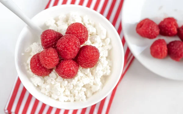 Requesón con frambuesas en un plato blanco en un tazón blanco — Foto de Stock