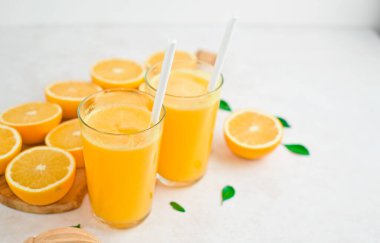 Taze portakal suyu ve portakallar kesim tahtasının üzerinde.