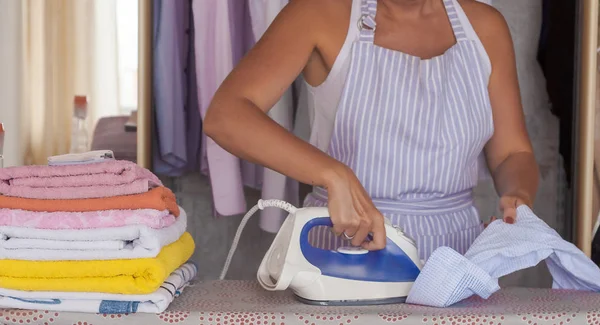 Wanita cantik muda menyetrika pakaian. Pekerjaan rumah tangga — Stok Foto