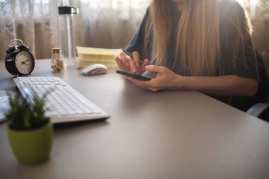 girl studying through a smartphone from home, online education concept
