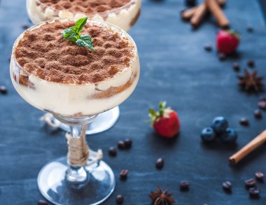 luxury tiramisu dessert in a cocktail glass decorated with cocoa