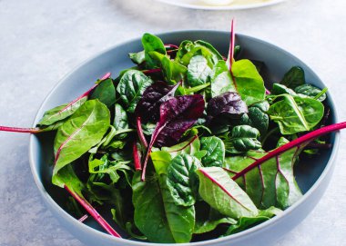 Mavi arka planda mavi bir kasede salata.