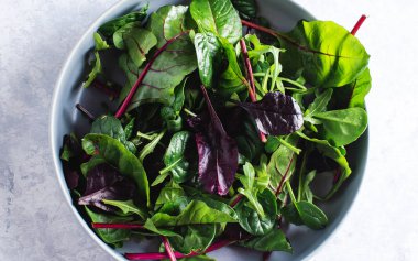 Mavi arka planda mavi bir kasede salata.